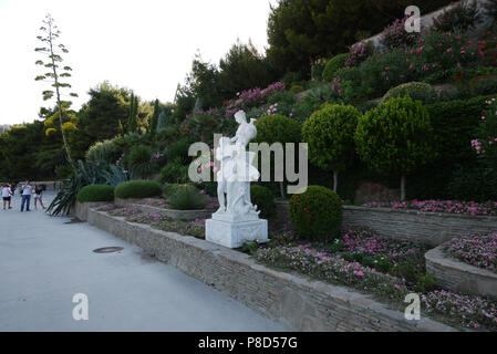 Un bel intérieur dans un parc aux parterres de fleurs l'article plusieurs étages sur une pente et arbres verts avec couronnes sphériques qui y poussent. . Banque D'Images