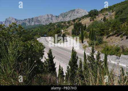 La route est tordue sur le fond de la falaise abrupte entourée par une forêt dense . Pour votre conception Banque D'Images