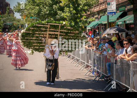Les participants à la 9e Parade des fleurs annuelles (Desfile de las Flores) dans le quartier de Jackson Heights Queens à New York, le dimanche 8 juillet 2018. Le défilé avec silleteros, vendeurs de fleurs, portant des médaillons de fleurs sur leur dos comme les silleteros qui les portent sur leur dos en bas de la montagne en Colombie autour de la ville de Medellin pour vendre au marché. Banque D'Images