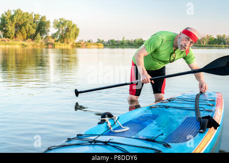 Portrait de l'environnement d'un pagayeur mâle avec un stand up paddleboard sur un lac calme dans le nord du Colorado, le paysage d'été Banque D'Images