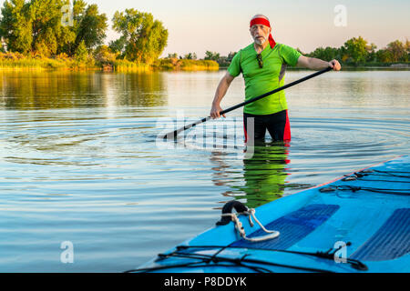 Portrait de l'environnement d'un pagayeur mâle avec un stand up paddleboard sur un lac calme dans le nord du Colorado, le paysage d'été Banque D'Images