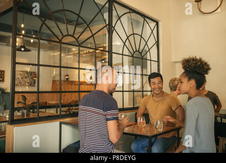 Divers jeunes amis de prendre un verre ensemble dans un bar Banque D'Images