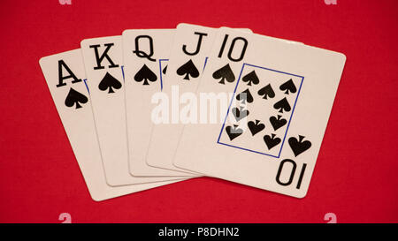 Main de poker Royal flush sur fond rouge. Banque D'Images
