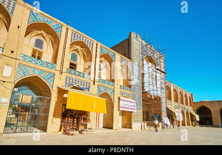 KERMAN, IRAN - 15 octobre 2017 : La façade de Ganjali Khan caravansérail avec des stands et des ateliers, sol carrelé iwan (portail) et niches voûtées traditiona - Banque D'Images