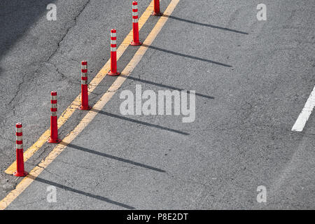 Double ligne de démarcation jaune et rouge d'avertissement en plastique gris asphalte autoroute sur poteaux Banque D'Images