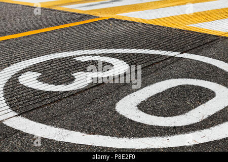 Signalisation de limite de vitesse avant de passage de piétons sur l'asphalte gris foncé Banque D'Images