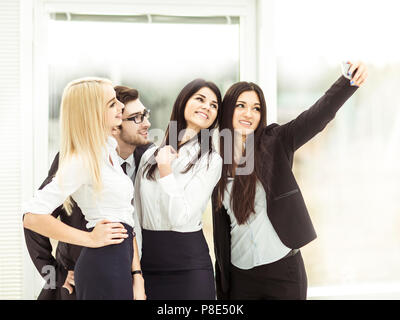 L'équipe d'affaires fait un dans le hall de selfies le bureau moderne Banque D'Images