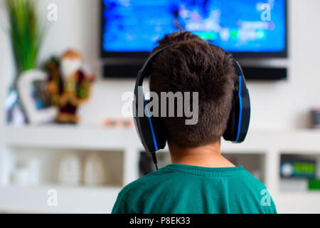 Garçon joue un jeu d'ordinateur à la maison Banque D'Images