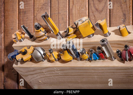 Close-up d'un grand ensemble d'exercices de métal pour une perceuse à main pour percer le bois sur une table en bois dans l'atelier Banque D'Images