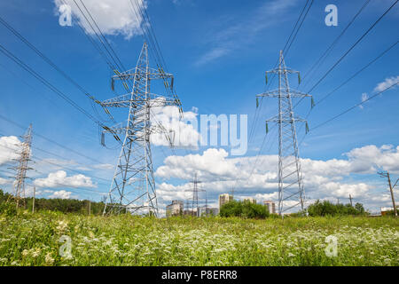 Ligne à haute tension passe à travers champ pour les immeubles de grande hauteur de la périphérie urbaine Banque D'Images