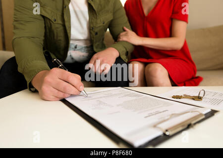 Jeune couple heureux de la signature du contrat d'achat immobilier. Banque D'Images