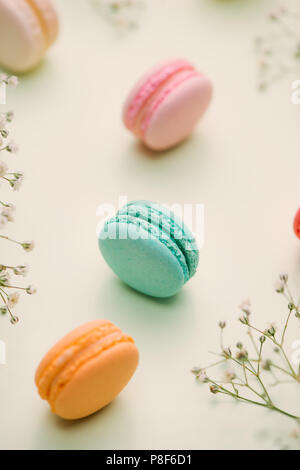 Matin cake macaron et fleur gypsophila sur fond vert clair à partir de ci-dessus. Petit déjeuner agréable. Mise à plat de style. Banque D'Images