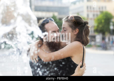 Couple standing par une fontaine d'eau hugging Banque D'Images