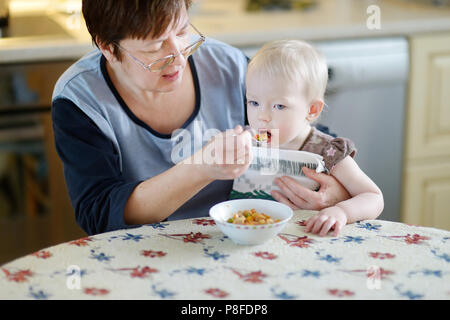 Grand-mère nourrit sa petite-fille petit bébé à la maison Banque D'Images