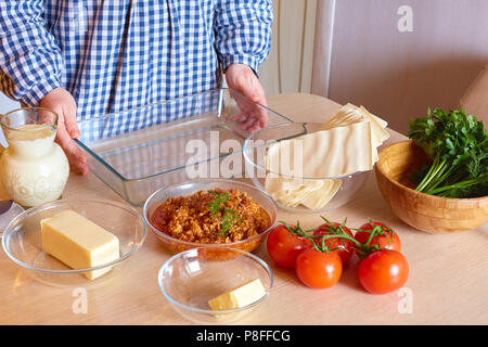 La ménagère lasagne à la viande cuisiniers dans la cuisine faite maison. Banque D'Images