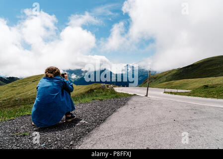 Vue arrière de la femme prise de photos sur route contre sky Banque D'Images