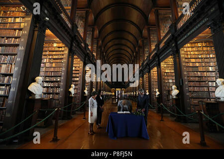 Le duc et la duchesse de Sussex Signez le livre, regardé par Trinity, Provost et le Président, le Dr Patrick Prendergast et College Bibliothécaire, Helen Shenton dans la longue pièce de l'ancienne bibliothèque dans le cadre de leur visite à Trinity College Dublin. Banque D'Images