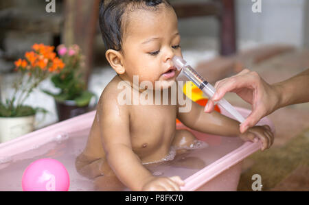 Bébé garçon asiatique de lavage nasal salin Banque D'Images