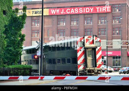 Chicago, Illinois, États-Unis. Un train de banlieue Metra à son approche finale de la gare Union négocie un virage à un passage à niveau. Banque D'Images