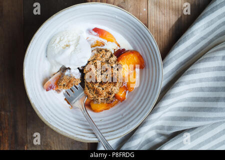 Peach cobbler dans un bol avec de la crème glacée Banque D'Images