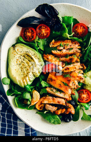 Salade de poulet aux herbes cétoniques comme la roquette, basilic et aneth frais, d'avocat, les olives, les graines et les tomates cerise avec avocat vinaigrette dans une salade en céramique Banque D'Images