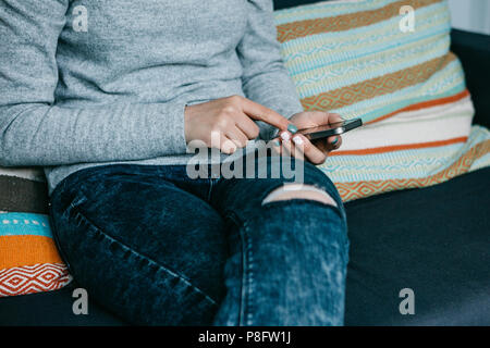 Une fille utilise un téléphone cellulaire pour appeler ou envoyer un message ou de communiquer dans un réseau social ou utilise l'application. Close-up Banque D'Images