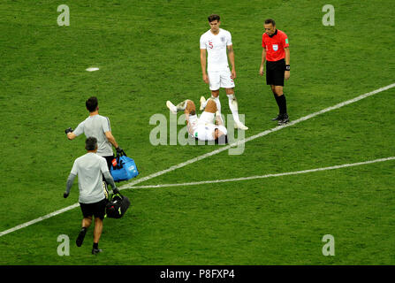 Kyle Walker de l'Angleterre (centre gauche) se trouve blessé sur le terrain comme match arbitre Cuneyt Cakir (droite) regarde avec John Stones (centre droit) de touche lors de la Coupe du Monde de football, demi-finale match au stade Luzhniki de Moscou. Banque D'Images