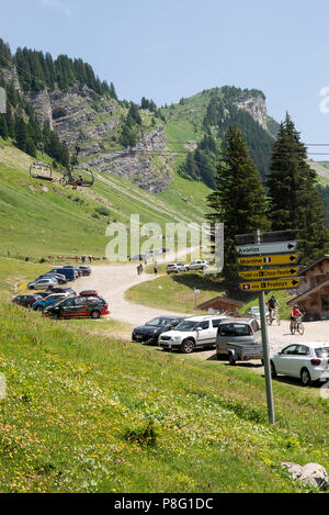 Les cyclistes de montagne prenant part à une longue distance à la montre les lindarets, dans les Alpes françaises avec panneau routier près de Montriond Haute-Savoie France Banque D'Images