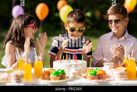 Enfants heureux avec le gâteau d'anniversaire à l'été Banque D'Images