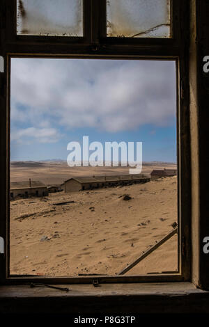 En regardant par la fenêtre de vieux bâtiments de la ville fantôme de Kolmanskop abandonnée en Afrique Namibie Namib dessert Banque D'Images