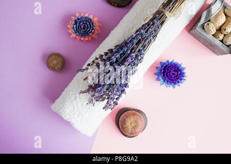 Beau savon dans la forme de fleurs et de serviette avec des fleurs de lavande pour des soins spa sur un fond bicolore. Focus sélectif. Banque D'Images