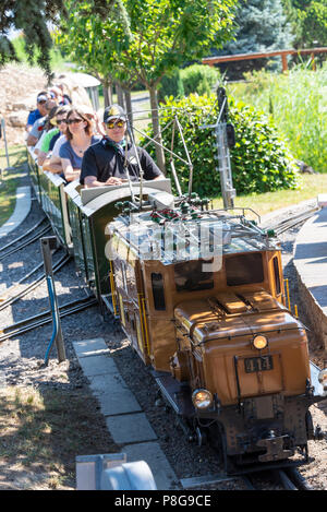 Un moteur électrique miniature tirant un train de voyageurs au Parc suisse des Vapeurs près du lac Léman au Bouveret Suisse Banque D'Images