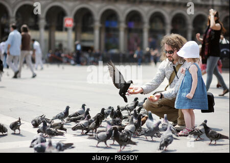 Adorable petite fille et son père se nourrir les pigeons à l'extérieur