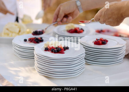 Waiter serving quelques plaques avec dessert Banque D'Images