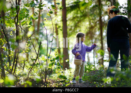 Grand-mère et sa petite-fille cueillir des baies dans la forêt Banque D'Images