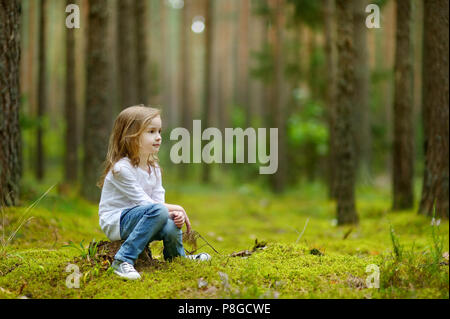 Adorable petite fille marche en forêt sur journée d'été Banque D'Images