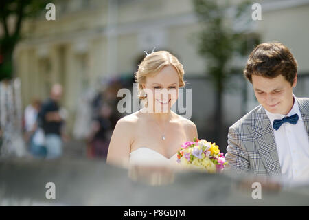 Mariée et le marié d'entrer dans une voiture de mariage vintage Banque D'Images