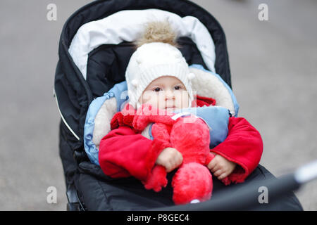 Cute smiling baby sitting dans une poussette sur une froide journée d'hiver Banque D'Images