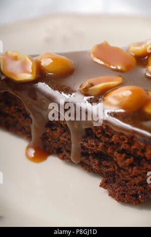 Close up d'un morceau de brownie gâteau au caramel au beurre salé et des cacahuètes grillées Banque D'Images