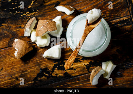 Beurre de noix de coco en bonne santé organique et morceaux de noix de coco fraîche sur fond de bois Banque D'Images