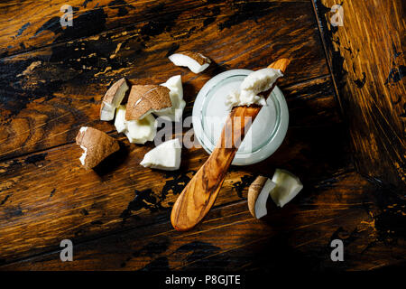 Beurre de noix de coco en bonne santé organique et morceaux de noix de coco fraîche sur fond de bois Banque D'Images