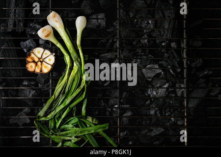 Légumes grillés à l'ail et oignon de printemps sur la grille barbecue sur charbon de bois. Vue de dessus, de l'espace. Concept de barbecue Banque D'Images