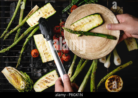 Légumes grillés à l'ail, l'asperge verte, citron, oignon de printemps, courgettes, tomates cerises, salade sur barbecue sur charbon de rack. La plaque et la cuisson Banque D'Images