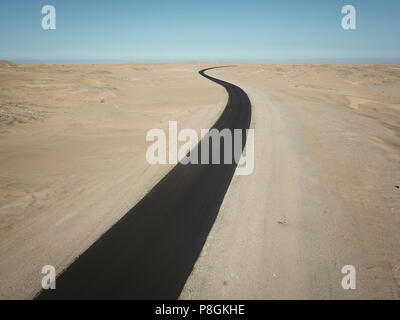 Longue ligne droite route goudronnée qui traverse un désert très sec en Namibie. Banque D'Images