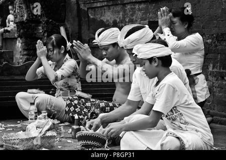 Une famille balinaise prie à PURA TIRTA EMPUL un temple hindou et complexes avec des sources froides eaux curatives - TAMPAKSIRING, BALI, INDONÉSIE Banque D'Images