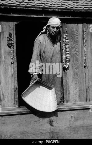 Une femme du cachemire tenant une pelle tissé dans sa Maison Bateau sur la rivière Jhelum - Cachemire, Inde Banque D'Images