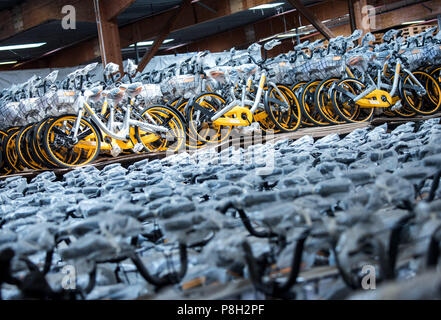 Barsbuettel, Allemagne. 10 juillet, 2018. Autour de 10 000 vélos à louer du prestataire Obike stand à côté de l'autre dans un dépôt. Dans plusieurs villes allemandes, les problèmes avec le jaune d'argent à louer des vélos de Obike sont de plus en plus. Crédit : Daniel Bockwoldt/dpa/Alamy Live News Banque D'Images