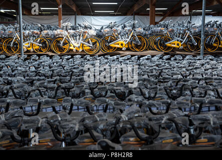 Barsbuettel, Allemagne. 10 juillet, 2018. Autour de 10 000 vélos à louer du prestataire Obike stand à côté de l'autre dans un dépôt. Dans plusieurs villes allemandes, les problèmes avec le jaune d'argent à louer des vélos de Obike sont de plus en plus. Crédit : Daniel Bockwoldt/dpa/Alamy Live News Banque D'Images