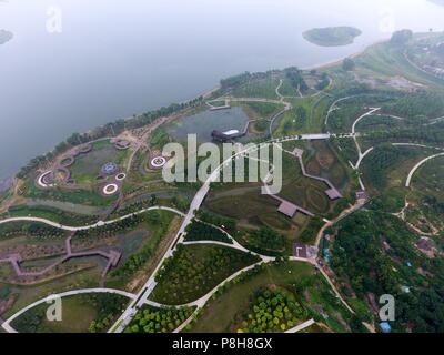 Zhengzh Zhengzh, Chine. 12 juillet, 2018. Zhengzhou, Chine-la 'Collines' faite de sols sous-évaluées et les déchets de construction peuvent être vus au parc forestier de Zhengzhou à Zhengzhou, province du Henan en Chine centrale.Le parc choisit de prendre les déchets et les sols en "collines", ce qui réduit la dépense de traiter les déchets. Crédit : SIPA Asie/ZUMA/Alamy Fil Live News Banque D'Images