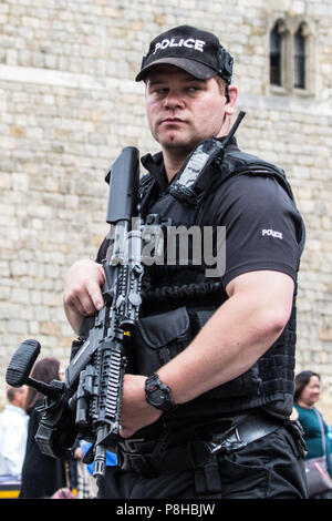 Windsor, Royaume-Uni. 12 juillet, 2018. Un agent de police lourdement armées à partir de la Thames Valley Police en service à l'extérieur du château de Windsor pour la relève de la garde. Les arrangements en matière de sécurité devraient être à l'honneur demain pour la visite de M. Trump au château de Windsor en tant que client de la Reine. Credit : Mark Kerrison/Alamy Live News Banque D'Images